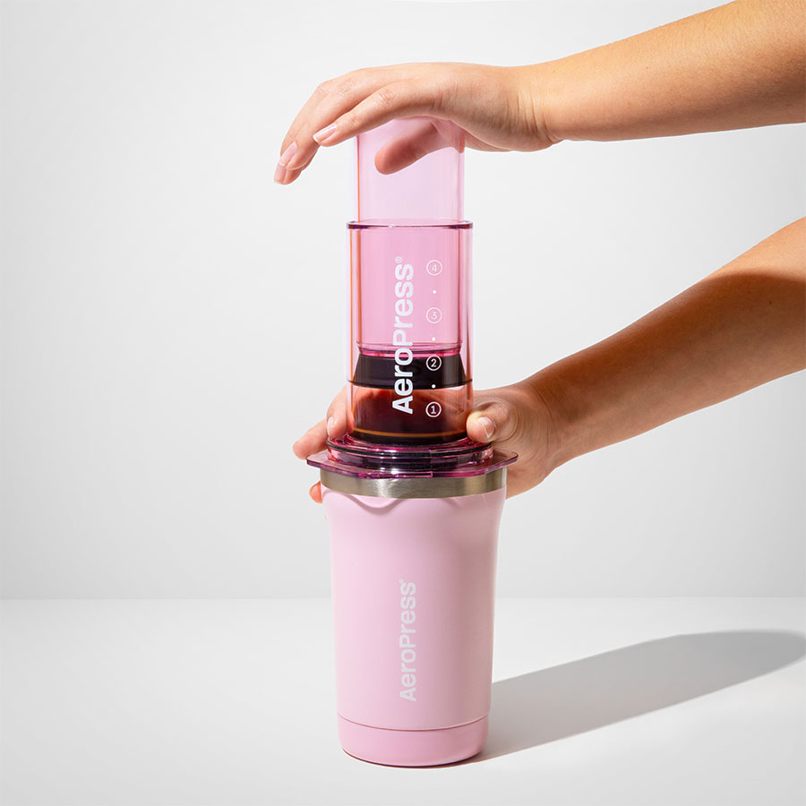 AeroPress Go Plus Travel System - Pink, pendant le pressage à deux mains - Coffee Coaching Club