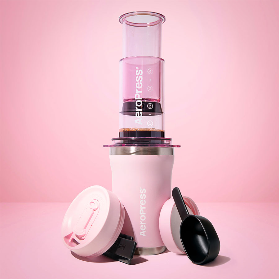 AeroPress Go Plus Travel System - Pink, Studioaufnahme mit Trinkbecher, Deckeln und Dosierlöffel - Coffee Coaching Club