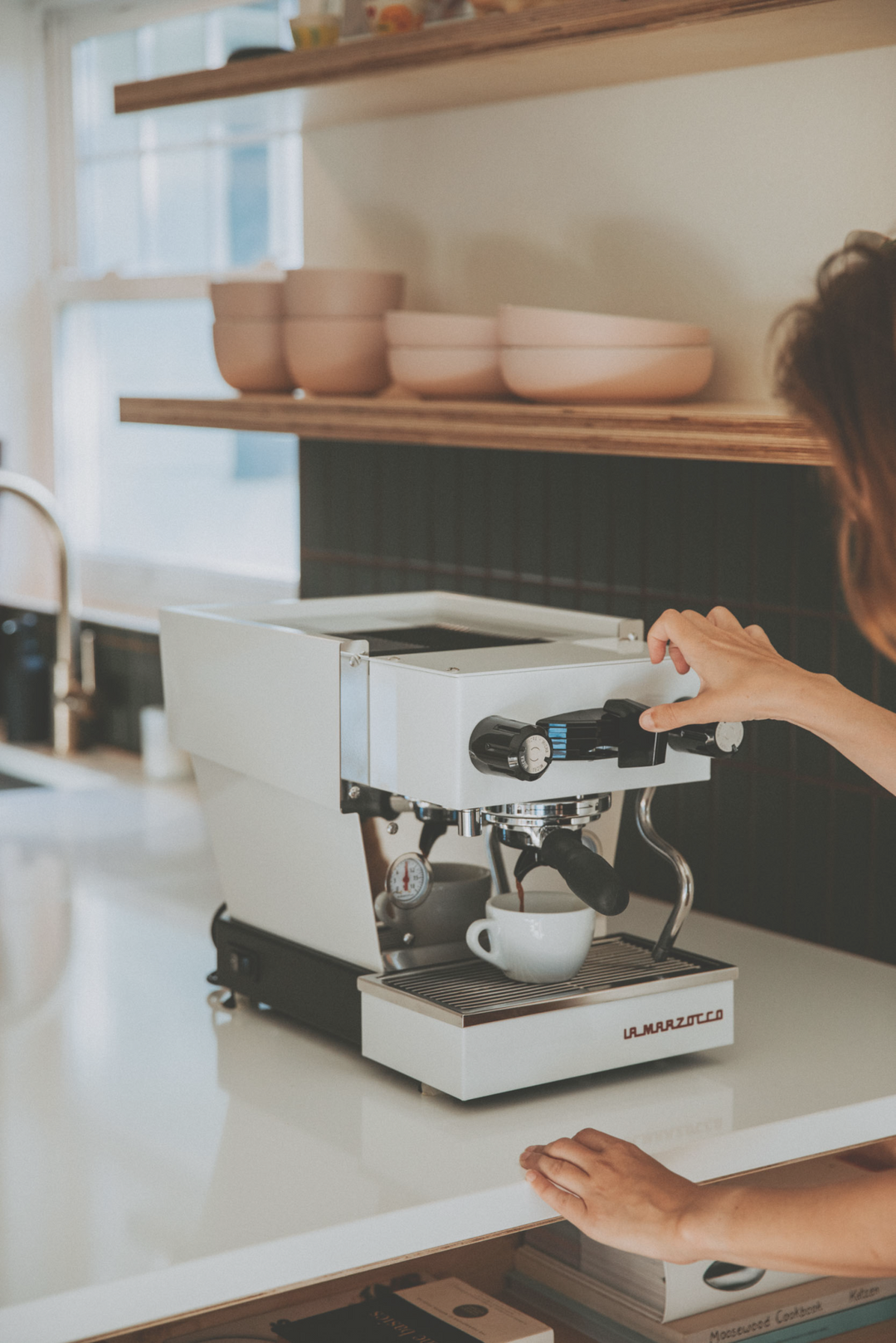 La Marzocco Linea Micra in white – lifestyle shot in a bright kitchen with a person – Coffee Coaching Club